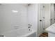 Clean, white tiled bathtub and shower combo with white door at 1146 Redan Way, Stone Mountain, GA 30088
