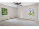 Empty bedroom with carpet, ceiling fan and two large windows with wooded view at 1146 Redan Way, Stone Mountain, GA 30088
