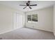 Bedroom with neutral carpet, closet, ceiling fan and view to the wooded backyard at 1146 Redan Way, Stone Mountain, GA 30088