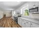 Bright kitchen with white cabinets, stainless steel appliances, granite countertops and wood-look flooring at 1146 Redan Way, Stone Mountain, GA 30088
