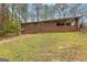 Large backyard with a brick home, grassy area, patio and mature trees at 1407 Highway 92 N, Fayetteville, GA 30214
