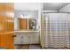 Well-lit bathroom featuring a vanity with granite countertop and a shower with striped curtain at 1407 Highway 92 N, Fayetteville, GA 30214