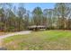 Brick ranch-style house with carport, featuring a long driveway, and a large grassy yard at 1407 Highway 92 N, Fayetteville, GA 30214
