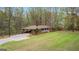 Brick ranch-style house with carport, featuring a long driveway, and a large grassy yard at 1407 Highway 92 N, Fayetteville, GA 30214