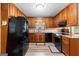 Traditional kitchen with wood cabinets, black appliances, and lots of counter space at 1407 Highway 92 N, Fayetteville, GA 30214