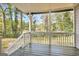 View from a covered back porch overlooking a wooded backyard with white railing at 2069 Sandtown Sw Rd, Atlanta, GA 30311