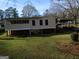 Exterior view of the back of the house, featuring a sunroom and a carport, with a spacious backyard at 3249 E Stratton Ln, Scottdale, GA 30079