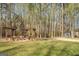 Spacious backyard featuring a fire pit, seating area, shed, and lush trees, perfect for outdoor gatherings at 1744 Elks Club Rd, Covington, GA 30014