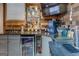 Modern wet bar with granite countertops, stainless steel bar fridge, and decorative wood paneling at 1744 Elks Club Rd, Covington, GA 30014