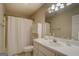 Clean bathroom with white vanity, toilet, shower with curtain, and large mirror at 1744 Elks Club Rd, Covington, GA 30014