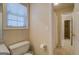Bright bathroom featuring a toilet and entry into shower and hallway at 1744 Elks Club Rd, Covington, GA 30014