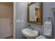 Small bathroom sink, toilet, mirror and adjacent storage provides all one needs in style at 1744 Elks Club Rd, Covington, GA 30014