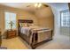 Cozy bedroom with decorative ceiling fan, large window, side table and luxurious bedding at 1744 Elks Club Rd, Covington, GA 30014