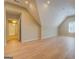 Spacious bedroom with a peaked ceiling, light hardwood floors, and an open doorway at 1744 Elks Club Rd, Covington, GA 30014