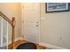 Cozy entryway with hardwood floors, wooden staircase and white front door with gold hardware at 1744 Elks Club Rd, Covington, GA 30014