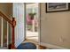 Bright entryway with hardwood floors, a wooden staircase, and view of landscaped yard beyond the open front door at 1744 Elks Club Rd, Covington, GA 30014