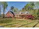 Charming brick home with a covered porch, rocking chairs, and manicured landscaping at 1744 Elks Club Rd, Covington, GA 30014