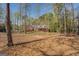 Brick home in a wooded area with mature trees and a lawn covered with fallen leaves at 1744 Elks Club Rd, Covington, GA 30014