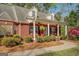 Charming brick home with a covered porch, rocking chairs, and well-maintained landscaping at 1744 Elks Club Rd, Covington, GA 30014