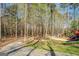 View of the fire pit area with a pergola and seating in a wooded setting at 1744 Elks Club Rd, Covington, GA 30014