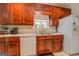 Traditional kitchen featuring wooden cabinets, white appliances, and a double stainless steel sink at 1744 Elks Club Rd, Covington, GA 30014