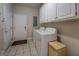 Bright laundry room featuring white appliances, ample cabinet space, and tile flooring at 1744 Elks Club Rd, Covington, GA 30014