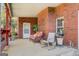Charming covered porch with brick exterior, seating, and a view of the landscaped yard at 1744 Elks Club Rd, Covington, GA 30014