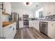 Well-lit kitchen features white cabinets, stainless steel appliances, and tile backsplash; modern appliances at 319 Honeysuckle Ter, Auburn, GA 30011