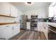 Bright kitchen with stainless steel appliances, white cabinetry, a subway tile backsplash, and wood countertops at 319 Honeysuckle Ter, Auburn, GA 30011