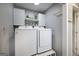 Convenient laundry room featuring modern washer and dryer set with storage cabinets at 319 Honeysuckle Ter, Auburn, GA 30011