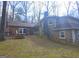 View of the home's exterior featuring a stone chimney, brick siding, and a deck with lattice at 3314 Henson Ln, Stockbridge, GA 30281