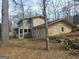 Home exterior showcasing the backyard with a mix of stone and siding, accented by mature trees, offering a blend of textures and natural beauty at 3314 Henson Ln, Stockbridge, GA 30281
