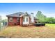 View of a brick home backyard with a wooden deck, and well-maintained lawn at 205 Wynnfield Way, Mcdonough, GA 30252