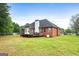 Exterior of a red brick home with a well-maintained backyard and a wooden deck at 205 Wynnfield Way, Mcdonough, GA 30252