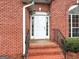 Close-up view of the brick home's front entrance with white door, sidelights, and iron railings at 205 Wynnfield Way, Mcdonough, GA 30252
