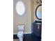 Powder room with unique oval window and ornate wood vanity, adding charm and character at 65 Lotus Ln, Covington, GA 30016