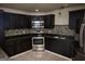 Stylish kitchen with stainless steel appliances, dark cabinets, and tile backsplash, ideal for cooking at 65 Lotus Ln, Covington, GA 30016