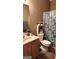 Bathroom with single sink vanity, floral accents, shower with patterned curtain, and neutral walls at 128 Astilbe Meadow Dr, Locust Grove, GA 30248