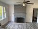 Open living room features a large fireplace, luxury vinyl flooring and big windows at 5147 Highpoint Rd, Union City, GA 30291
