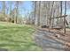 Backyard featuring a wooden swing, fire pit, landscaped yard and mature trees at 100 Smokerise Trce, Peachtree City, GA 30269