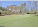 Large backyard with mature trees and landscaping surrounding the home at 100 Smokerise Trce, Peachtree City, GA 30269