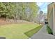 Spacious backyard featuring lush green lawn, a stone retaining wall and landscaping at 100 Smokerise Trce, Peachtree City, GA 30269
