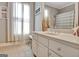 A bathroom with a vanity featuring a double sink, a mirror, and a bench at 100 Smokerise Trce, Peachtree City, GA 30269