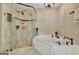 Elegant bathroom featuring tiled shower with glass door and soaking tub with bronze fixtures at 100 Smokerise Trce, Peachtree City, GA 30269