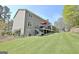Exterior view of home featuring large grassy lawn and back deck at 100 Smokerise Trce, Peachtree City, GA 30269