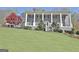 Charming two-story house featuring a columned porch and landscaped front yard on a sunny day at 100 Smokerise Trce, Peachtree City, GA 30269