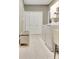 Bright laundry room with tile flooring, washer, dryer, closet and storage bench at 100 Smokerise Trce, Peachtree City, GA 30269