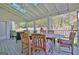 Covered patio with vaulted ceiling features ceiling fan, skylight and dining table with outdoor seating at 100 Smokerise Trce, Peachtree City, GA 30269