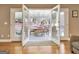 View of the porch from the living room through glass doors with a wooden table and chairs at 100 Smokerise Trce, Peachtree City, GA 30269