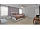 Elegant bedroom with a queen-sized bed, side tables, dresser, armchair, and a purple accent wall provides a luxurious retreat at 517 Daffodil Ln, Mcdonough, GA 30253
